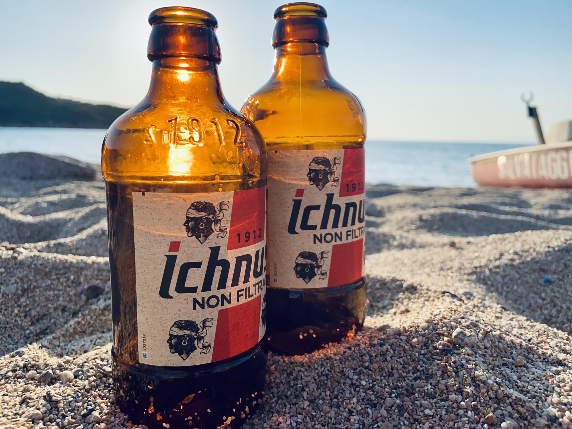 Aperitivo al tramonto sulla spiaggia di Porto Quadro, due birre Ichnusa sulla sabbia con il mare sullo sfondo